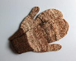 handgemaakt bruin-beige wanten van Argentijns merino wol Aan een wit achtergrond. foto