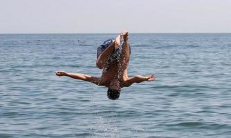 Mens jumping in de water foto