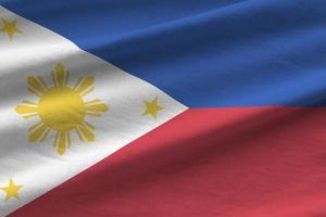 Filippijnen vlag met groot vouwen golvend dichtbij omhoog onder de studio licht binnenshuis. de officieel symbolen en kleuren in banier foto