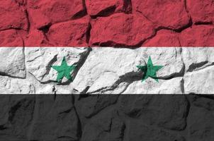 Syrië vlag afgebeeld in verf kleuren Aan oud steen muur detailopname. getextureerde banier Aan rots muur achtergrond foto