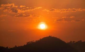 de zon Aan de oranje lucht in de ochtend- en de berg visie foto