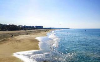 strand zand blauw water reusachtig surfer golven puerto escondido Mexico. foto