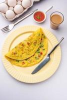 Indisch gekruid masala omelet gevulde met vers groente, gezond maaltijd foto