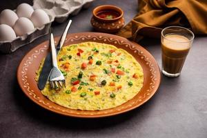 Indisch gekruid masala omelet gevulde met vers groente, gezond maaltijd foto