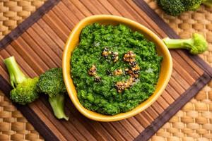 vers broccoli chutney of Plakken, puree in de kom met rauw stukken foto