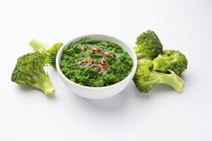 vers broccoli chutney of Plakken, puree in de kom met rauw stukken foto