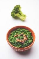 vers broccoli chutney of Plakken, puree in de kom met rauw stukken foto