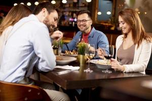 jong mensen hebben avondeten in de restaurant foto