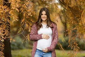 jonge zwangere vrouw in de herfst park foto