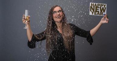 mooi vrouw vieren nieuw jaar met confetti en Champagne Holding teken. geïsoleerd foto