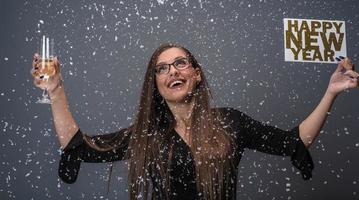 mooi vrouw vieren nieuw jaar met confetti en Champagne Holding teken. geïsoleerd foto