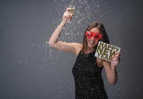 mooi vrouw vieren nieuw jaar met confetti en Champagne Holding teken. geïsoleerd foto