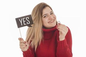 vrouw Holding verloving ring en teken gezegde Ja foto