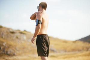 atletisch jong Mens uitrekken na rennen in de natuur. sport concept foto