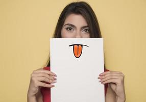 jong glimlachen vrouw Holding een blanco vel van papier voor reclame foto