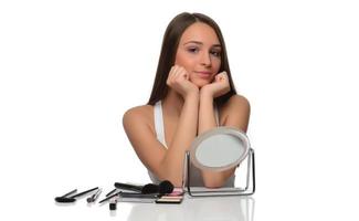 acne vooroverliggend huid concept. jong vrouw op zoek Bij spiegel Bij huis, controle haar gezicht huid foto
