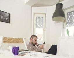 jong bedrijf Mens werken Bij huis met papieren Aan bureau foto