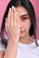 foto van jong aantrekkelijk vrouw Hoes oog arm controle visie oogheelkunde geïsoleerd over- roze kleur achtergrond
