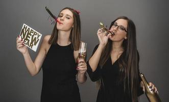 twee vrouw vrienden vieren nieuw jaar met confetti en Champagne Holding teken. geïsoleerd foto