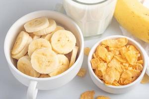 cornflakes ontbijt, banaan, vers melk, gezond voedsel foto