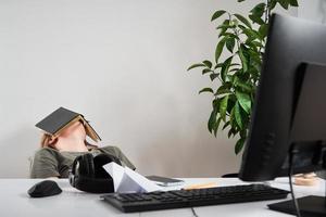 verveeld vrouw slaap Bij werkplek. afgelegen werk Bij huis foto