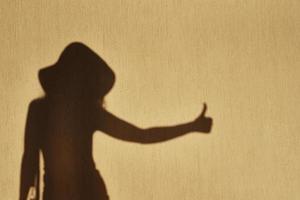 schaduw van vrouw shows duim omhoog gebaar Aan de muur foto
