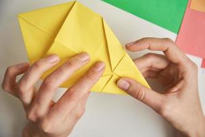 diy concept. vrouw maken origami Pasen konijn van kleur papier. origami lessen foto