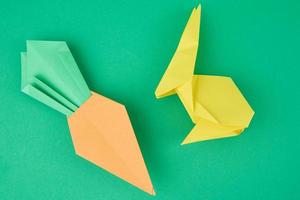 papier origami konijn en wortel Aan groen achtergrond foto