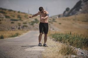 atletisch jong Mens uitrekken na rennen in de natuur. sport concept foto