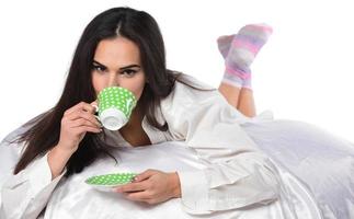 vrolijk inschrijving vrouw zittend met kop van koffie Aan worden foto