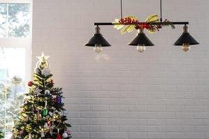 de zwart lampenkap in de industrieel zolder stijl is versierd met net takken voor Kerstmis en nieuw jaar Aan de achtergrond wit steen muur. detailopname, minimalisme foto