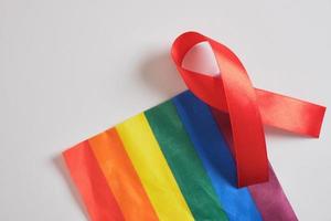 hou op AIDS, hiv concept. rood lint tegen Aan vlag van lgbt trots foto