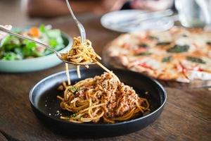 aan het eten voedsel. mensen aan het eten Italiaans voedsel pasta, pizza, salade Aan de tafel. foto