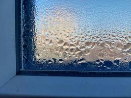venster gedekt met bevroren druppels van condensaat water foto