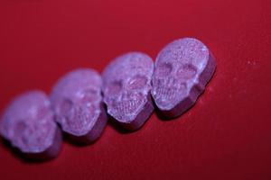 roze schedel extase pil dichtbij omhoog achtergrond hoog kwaliteit afdrukken Purper leger dope verdovende middelen stof hoog dosis psychedelisch manier van leven foto