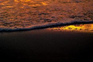 detailopname golven schot Bij zonsondergang foto