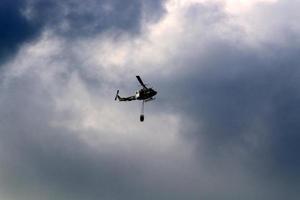 een helikopter zet uit een Woud brand in de bergen van noordelijk Israël. foto