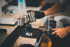 barista cafe maken koffie met handleiding hefboom espresso machine voorbereiding onderhoud concept in restaurant.close omhoog hand- barista maken vers koffie met koffie machine cafe. maken vers koffie espresso foto