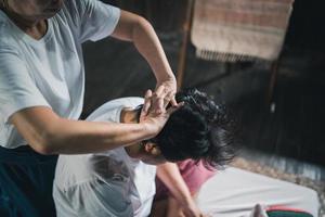 massage en spa ontspannende behandeling van kantoor syndroom traditioneel Thais massage stijl. asain senior vrouw masseuse aan het doen massage traktatie hoofd, terug pijn, arm pijn, voet en spanning voor oud vrouw moe. foto