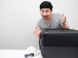 Aziatisch Mens met bagage gebaar gelukkig met vakantie kopiëren ruimte foto