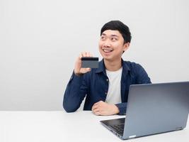 Mens glimlachen en Holding credit kaart op zoek Bij kopiëren ruimte foto