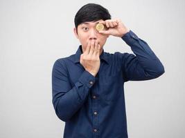 Aziatisch Mens dichtbij zijn mond en dichtbij zijn oog door bitcoin gevoel opgewonden Aan wit achtergrond foto