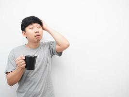 Aziatisch Mens slaperig emotie Holding koffie kop op zoek Bij kopiëren ruimte foto