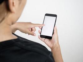 achterkant van vrouw tintje scherm Aan mobiel telefoon wit scherm voor controleren sociaal media en boodschappen doen foto