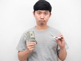 Mens verveeld emotie Holding thermometer met geld wit achtergrond portret foto