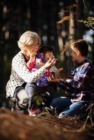gelukkig grootmoeder, kleindochter en kleinzoon spelen in de park foto