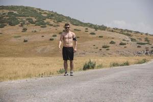 jong Mens loper rennen Aan een berg weg. jogger opleiding training in geschiktheid schoen. gezond levensstijl en sport concept. beweging vervagen en selectief focus. foto