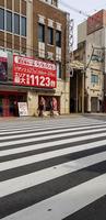 osaka, Japan Aan april 10, 2019. twee Aziatisch mannen wandelen naar beneden een steeg in een dorp in Osaka in de overgang van voorjaar naar zomer, foto