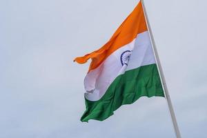 indiase vlag hoog op connaught plaats met trots in blauwe lucht, indiase vlag wapperen, indiase vlag op onafhankelijkheidsdag en republiek dag van india, tilt-up shot, wuivende indische vlag, har ghar tiranga foto