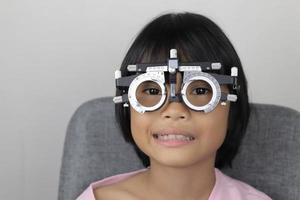 meisje oog testen, test oog concept, meisje vervelend beproeving kader bril foto